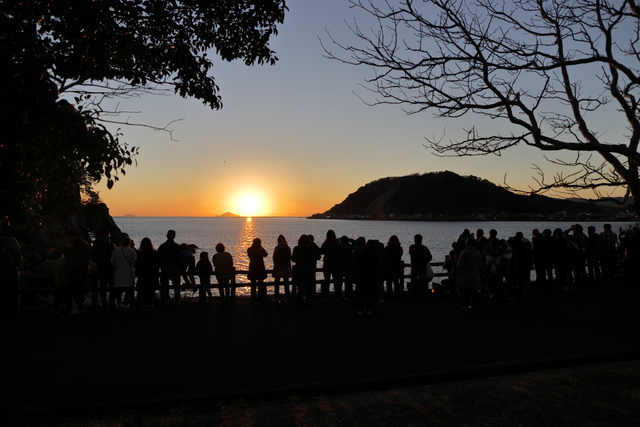 だるま夕日を見る人々